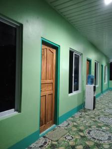 een kamer met groene muren en een deur bij BARRIL GREEN HOMESTAY in Batuan