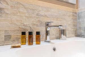 2 bottiglie di oli essenziali poggiano su un lavandino del bagno di Spagna Boutique a Roma Altre 77 foto