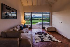 a living room with a couch and a large window at The Landing Nanyuki - One Bedroom Guest house in Nanyuki