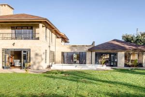 a house with a green lawn in front of it at The Landing Nanyuki - One Bedroom Guest house in Nanyuki