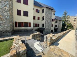un edificio con un muro di pietra accanto a un edificio di C09 - Apartamento Pirineos - Villmor a Cerler