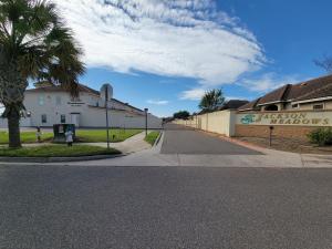 an empty street with a building and a palm tree at Modern, Private, Smart 4 BR Condo in Desirable Location in McAllen with Pool! in McAllen