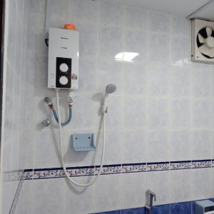 a shower in a bathroom with a microphone on a wall at Family Beach Condo PD at Cocobay Resort Condominium in Port Dickson