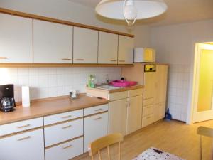 a kitchen with white cabinets and a sink at unser Ferienhaus in Hempel