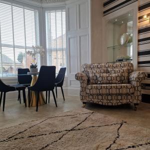 uma sala de estar com um sofá, uma mesa e cadeiras em No 9 retreat em Prestwick