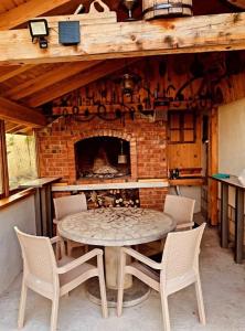 a table and chairs in front of a brick fireplace at Planinska kuća za odmor Perić in Prozor