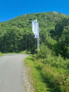 un panneau indiquant la rue sur le côté d'une route dans l'établissement Hausvikstranda, à Lyngdal