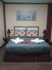 een slaapkamer met een bed met twee handdoeken erop bij Peace Lily Studio Apartments Panglao in Panglao