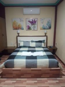 een slaapkamer met een groot bed en 2 handdoeken bij Peace Lily Studio Apartments Panglao in Panglao