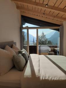 a bedroom with a bed and a large window at Alpine Apartments St-Sigmund in Sankt Sigmund im Sellrain
