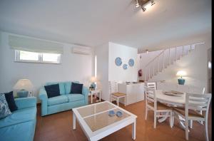 a living room with a blue couch and a table at Casa da Prainha - private pool, next to the beach in Alvor