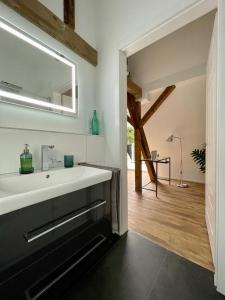 W łazience znajduje się biała umywalka i lustro. w obiekcie DESIGN-Studio CHURCH 46 w mieście Mülheim an der Ruhr