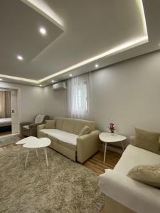 uma sala de estar com um sofá e duas mesas em Apartments Natural and Bungalows em Saraievo
