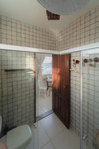 a bathroom with a shower and a glass door at Pousada Recanto da Família in Natal