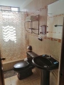 ワンカヨにあるDepartamento D&C I entero acogedorのバスルーム(黒いトイレ、シンク付)