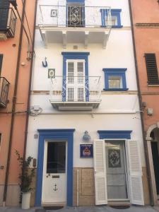 a white building with blue doors and a balcony at Acasadelpescatore in San Benedetto del Tronto