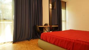 a bedroom with a bed and a table and a window at Valmarana Morosini Hotel in Altavilla Vicentina