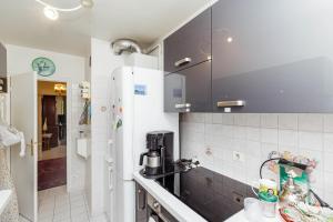 a small kitchen with a refrigerator and a sink at Spacious T3 with view in the heart of the city! in Charenton-le-Pont