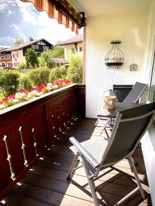 a deck with a table and a chair on a porch at Allgäu-Ferienwohnung Jung in Fischen
