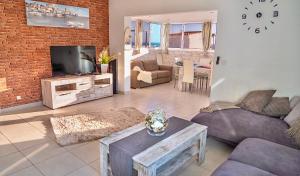 uma sala de estar com um sofá e uma televisão em Villa Casa Amada em Callao Salvaje