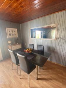 a dining room table with chairs and a bowl of fruit on it at Smokvica in Stari Slankamen +19 photos