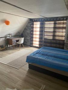 a bedroom with a bed and a desk and window at Smokvica in Stari Slankamen