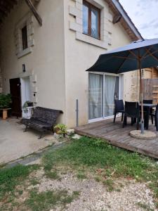 taras z parasolem, stołem i krzesłami w obiekcie Loft ravissant avec parking gratuit sur place w mieście Lédat +4 zdjęcia
