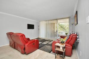 ein Wohnzimmer mit 2 roten Stühlen und einem TV in der Unterkunft Double Master Suites - 206 in Houston