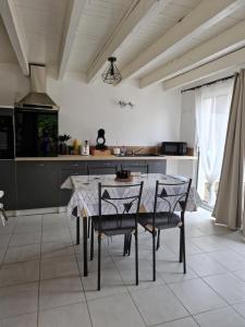 cocina con mesa y sillas en una habitación en Loft ravissant avec parking gratuit sur place, en Lédat