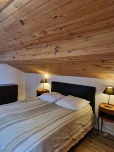 sypialnia z dużym łóżkiem i drewnianym sufitem w obiekcie Loft ravissant avec parking gratuit sur place w mieście Lédat