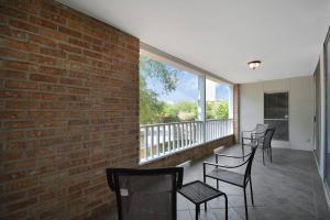 einen Balkon mit Stühlen und einer Ziegelwand in der Unterkunft Double Master Suites - 206 in Houston