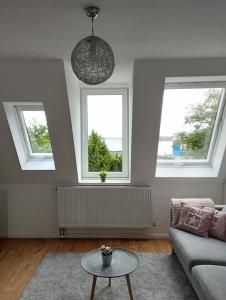 ein Wohnzimmer mit 2 Fenstern und einem Sofa in der Unterkunft Meer-Harmonie in Kiel