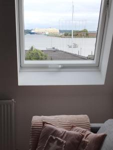 ein Fenster in einem Schlafzimmer mit Blick auf das Wasser in der Unterkunft Meer-Harmonie in Kiel