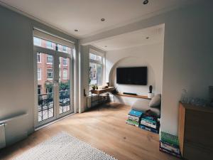 a living room with a large window and a television at Spacious Designer Duplex next to Central Park in Amsterdam