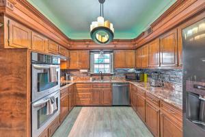 a large kitchen with wooden cabinets and a chandelier at Spacious Memphis Home Less Than 3 Mi to Graceland! in Memphis