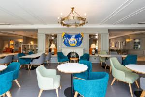 restauracja ze stołami i krzesłami oraz kominkiem w obiekcie Holiday Inn Maidstone-Sevenoaks, an IHG Hotel w mieście Maidstone