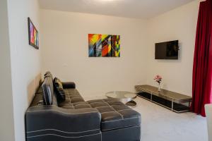 a living room with a couch and a tv at Brand new 2-bedroom apartment 2 km from Eagle beach in Palm-Eagle Beach