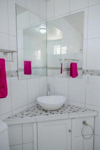 a white bathroom with a sink and a mirror at Brand new 2-bedroom apartment 2 km from Eagle beach in Palm-Eagle Beach