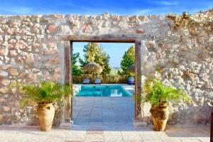 kamienna ściana z basenem i dwoma doniczkami w obiekcie Room in Villa - Beautiful Accommodation At The Heart Of Andalusia w mieście Puente-Genil +29 zdjęć