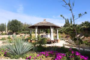 un cenador en un jardín con flores púrpuras en Room in Villa - Beautiful Accommodation At The Heart Of Andalusia, en Puente Genil