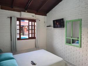 Habitación con cama, espejo y ventana en Sunshine Residencial en Bombinhas