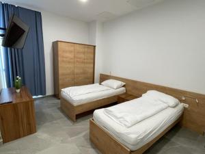 a room with two beds and a flat screen tv at Wels Inn City Apartments in Wels