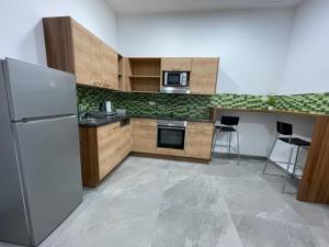 uma cozinha com um frigorífico e um fogão forno superior em Wels Inn City Apartments em Wels