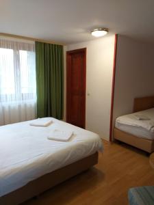 a hotel room with two beds and a window at Rapsodia Muntilor in Stațiunea Climaterică Sâmbăta
