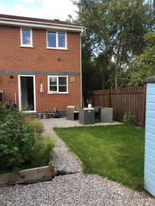 a backyard of a brick house with a patio at Cheerful 2-bedroom home with free parking in Roughhill