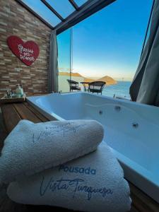 a bath tub with a view of the ocean at Pousada e Restaurante Vista Turquesa in Arraial do Cabo