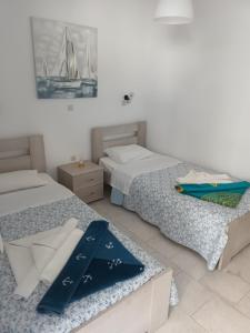 a bedroom with two beds and a painting on the wall at Holidays in Paros in Aliki