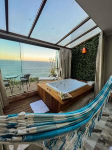a hammock and a tub in a room with a view at Pousada e Restaurante Vista Turquesa in Arraial do Cabo