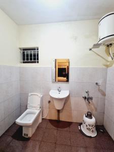 a bathroom with a toilet and a sink at HAVEN COTTAGE in Ooty