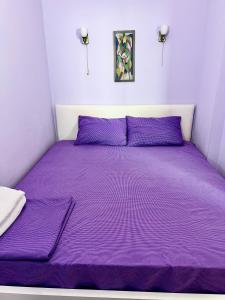 una cama con colcha púrpura en una habitación en Fantastic View on Chisinau Center - Super Fast WiFi - Two Botanical Gardens - 2BR en Chişinău